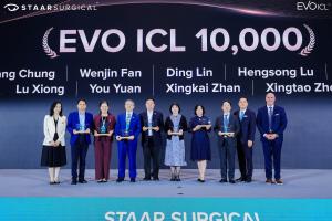 Group of ophthalmologists on stage receiving awards at the EVO ICL Summit, with a large “EVO ICL 10,000” display behind them.