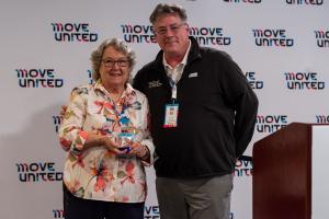 Barb Peacock accepts the Jim Winthers Volunteer Award from Move United CEO Glenn Merry