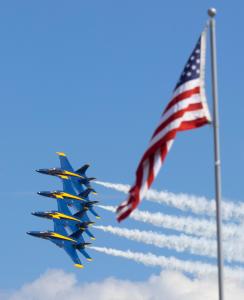 U.S. Navy Blue Angels aircraft fly in formation beside an American flag during an Air Dot Show performance ahead of the Memorial Day weekend 2026 Air Dot Show Central PA event at Harrisburg International Airport.