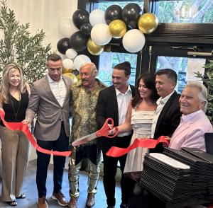 Restaurant owners and management gather for the ribbon cutting at the grand reopening of The Grille on Congress in Boca Raton, Florida.