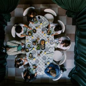 Overhead view of Event Summit attendees seated around a styled dining table during a conference meal experience