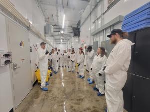 An image of people inside a cannabis cultivation facility and listening to the speaker.