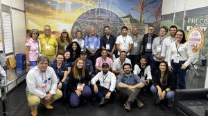 Un grupo de aproximadamente 25 personas posa reunido para una foto oficial de la ronda internacional de negocios de Brazil Machinery Solutions (BMS). Los participantes están distribuidos en tres filas, algunos de pie y otros agachados al frente. Hombres y