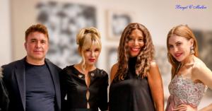Birgit C. Muller, three-time Emmy Award-winning bespoke couture designer, poses with guests at her Fashion and Art Pop-Up event at 124 Lasky Drive, Beverly Hills, May 2026, with Sanya Ilich art exhibition visible in the background.