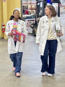 Ava N. Simmons Planning The Fuel The Future STEAM Donation Drive Distribution Activities with DECI's Kara Von Blon. They are walking with lab coats on