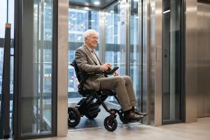 Person using the Jazzy Assist power wheelchair inside an elevator with EZ-Pass™ turning assistance technology.