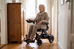 User driving the Jazzy Assist power wheelchair through a narrow home interior using EZ-Pass™ mobility assistance.
