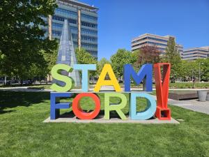 Colorful, iconic sculpture spells the word "Stamford" set against a beautiful sunny day.