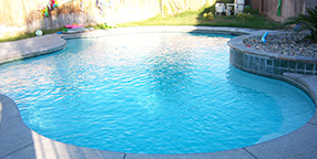 A sparkling blue backyard swimming pool in the Central Valley, illustrating the high standard of maintenance required to prevent excessive evaporation and chemical waste.