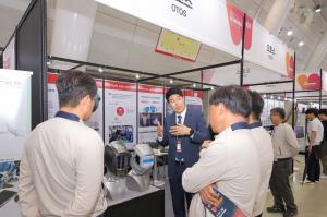 An official from OTOS Technology introducing Welding Camera Helmets to buyers at the company booth
