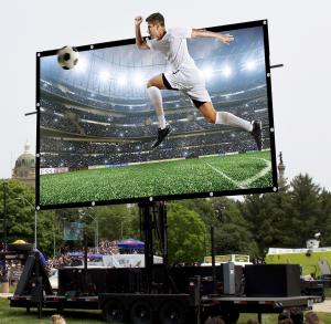 Soccer player breaking out of the large TV screen showing the exciting experience of watching soccer games.