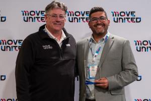 Glenn Merry and Evan Enquist pose holding the award