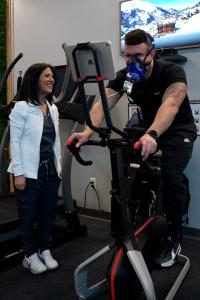 Patient performing VO₂ max cardiovascular testing on a stationary bike at MetaLab by Confidia in Bristol, Connecticut while monitored by clinical staff.