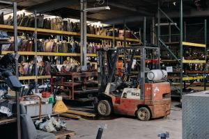 Interior of Select Auto Parts & Sales in Milwaukee showing parts racks, inventory, and a forklift inside the company’s indoor auto recycling facility.
