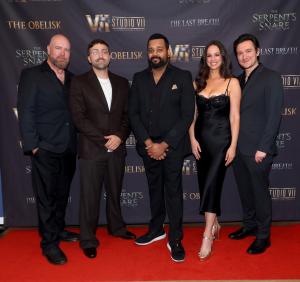 Adrian Honner, Andrew Johnston, Neil Karunatilaka, Kayla Swift and Eddie Davies pose on a red carpet in front of a Studio VII step-and-repeat backdrop at a private first-look presentation for THE PROLOGUE: THE DEAD DO NOT RETURN in North Hollywood, California.