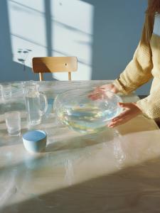 A home practice station with bowls and cups on a table, used for adult water comfort and breath control exercises.