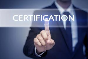 photo of a man in a dress suit pointing to a large screen with the words Certification
