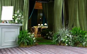 Moss-layered entry installation with lush greenery and white floral arrangements welcomes guests to the Thaden School gala. Photo by Kaity Whitman, Rose of Sharon Floral Design Studio.