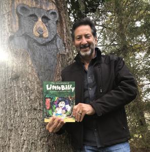 Author Barry Farber stands beside a tree carving of Bosco the Bear he made while holding a copy of The Adventures of Little Billy: In Search of the Magic Tree outdoors.