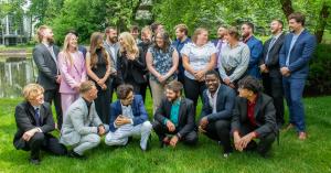 The 500 Republic team posing together outdoors in professional attire near a pond and trees.