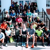 Participants and volunteers gather on outdoor steps during the Frederick Run Like a Warrior community fun run and tick-borne disease awareness event.