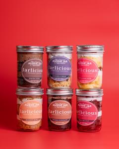 Jarlicious Cupcakes 6 flavours labelled. 3 flavours on the bottom from left to right are Biscoff Bliss, Double Chocolate Indulgence and Red Velvet. 3 flavours on top from left to right are Mocha Swirl, Cookies and Cream, and Vanilla Berry Bliss. All jars 