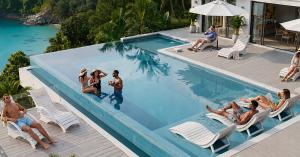 AquaCurve in-pool lounge chairs on a backyard pool sun shelf with shallow water
