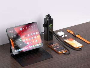 ReelCharge 200W portable charger with integrated 140W USB-C cable charging an iPad, two smartphones, wireless earbuds, and a smartwatch on a wooden desk.