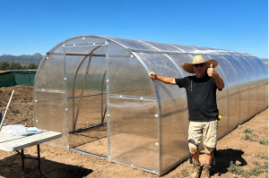 Mark, a YourGreenhouses customer, stands beside his polycarbonate greenhouse on his five-acre property in Arizona.