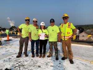Construction Roofers on top of a building with a Houk representative