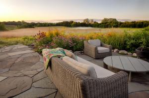 A misty prairie landscape rolling over gentle hills, designed to reflect the natural character of a 66-acre property. Native grasses and pollinator-friendly plantings create a restored prairie habitat, while the surrounding landscape blends seamlessly int
