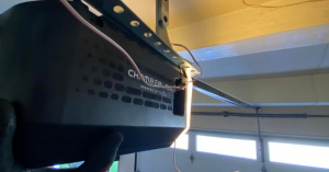 A professional technician diagnosing and repairing the internal gears of a LiftMaster garage door opener mounted to a ceiling in a Pasadena home.
