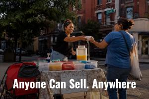 Young Latina woman smiling as she hands food to a customer across a folding table on a city street corner, selling empanadas with a handwritten cash-only sign, text overlay reads "Anyone Can Sell. Anywhere."