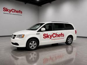 White minivan with red logo that says Sky Chefs