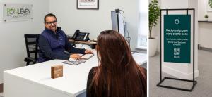 BonLeven Healthcare provider meeting with a patient in a modern medical office while branded migraine care signage stands nearby promoting digital tracking and patient support services.