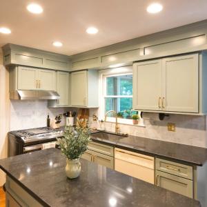 Cabinets extended to the ceiling Existing cabinet boxes refaced Bright white cabinet finish Updated kitchen island Shaker-style doors and panels Added upper storage space