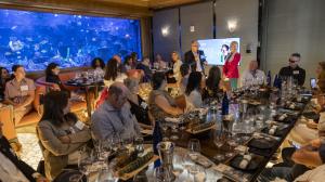 people attend a wine lunch in front of a large aquarium