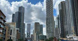 View of Canary Wharf in London featuring modern financial district skyscrapers and waterfront buildings.