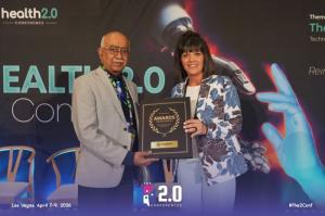 “Dr. Ravi R. Iyer accepts the ‘Outstanding Organization Award’ on behalf of ActivPower Inc. at the Health 2.0 Conference in Las Vegas, April 2026, standing alongside a conference representative while holding the award plaque on stage.”