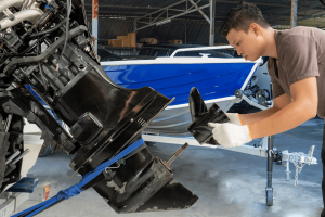 Marine repair shop worker installing outboard