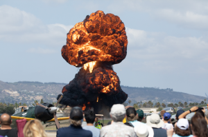 Massive orange and black fireball rises into the sky during the airshow in Camarillo, California, while attendees watch from nearby viewing areas. Camarillo is a city within Ventura County Coast.