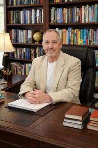 Professional portrait of children’s author Jeffrey R. Samoranski seated in his office library