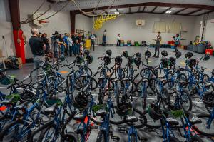 60 new bicycles in a hall with people gather to present them to a charity