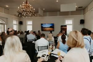 Attendees seated at the Lakeview Village launch event in Winter Garden, Florida, watching a presentation by Davila Homes on May 21, 2026.