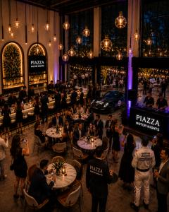 Guests gather among curated vehicles, cocktails, music, and hospitality experiences during PIAZZA Motor Nights.