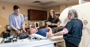 Physician and imaging staff supervising a patient during a contrast-enhanced CT scan using Tether Supervision’s real-time clinical support workflow.