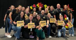 Group of corporate event participants smiling and holding winner certificates after a Strayboots team-building activity.