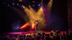 Anuv Jain performs live on stage during his sold out Dastakhat World Tour 2026 concert in Atlanta, surrounded by dramatic stage lighting as fans watch and record the performance. Photo by Chirag Patel for Kash Patel Productions.