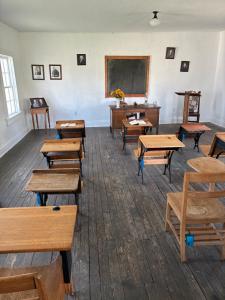 An old-timey school house interior with pictures of historic figures & presidents on the walls.