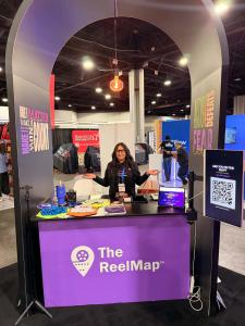 The ReelMap conference booth at Keller Williams Family Reunion featuring branded displays, QR code engagement, and video marketing tools for real estate agents.